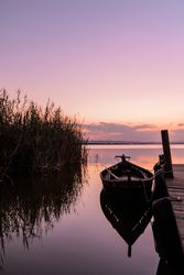 Moored boat by wooden pier