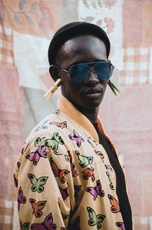 Man in butterfly print jacket and peg earrings