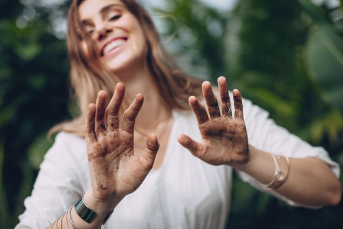 Female gardener showing her dirty hands with soil and earth
