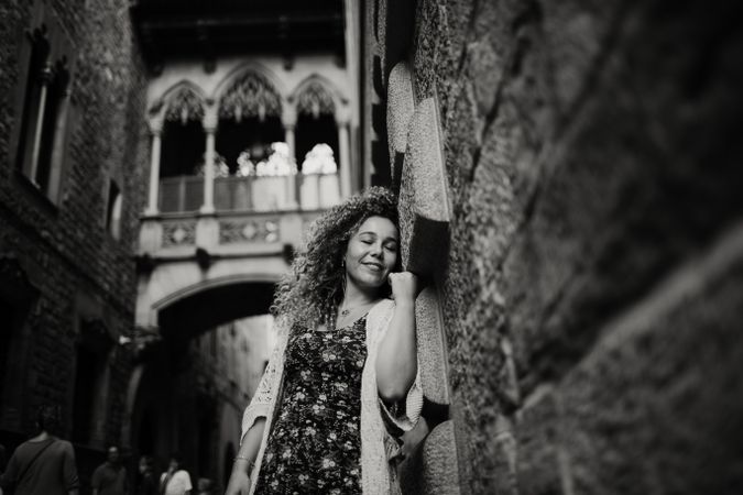 Adult woman leaning on old stone wall