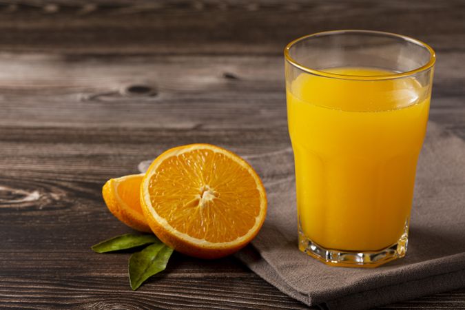 Glass with orange juice on the table.