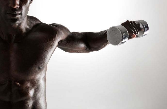 Shot of young muscular man doing dumbbell exercise for arms