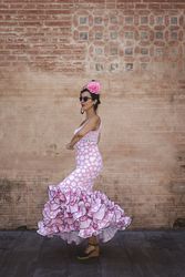 Passionate woman in flamenco dress dancing on street