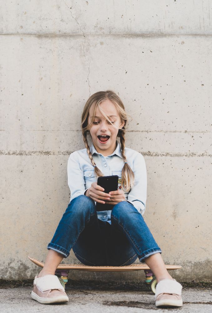 Kid using mobile phone with skate
