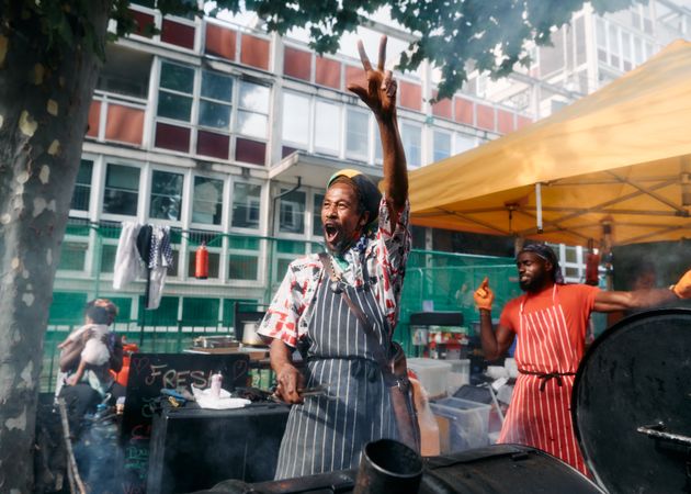 London, England, United Kingdom - August 27, 2022: Two happy men cooking street food at carnival