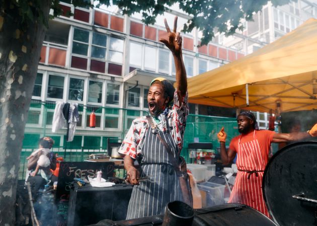 London, England, United Kingdom - August 27, 2022: Two happy men cooking street food at carnival