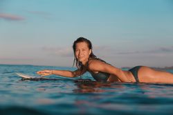 Smiling woman on surf board floating on water