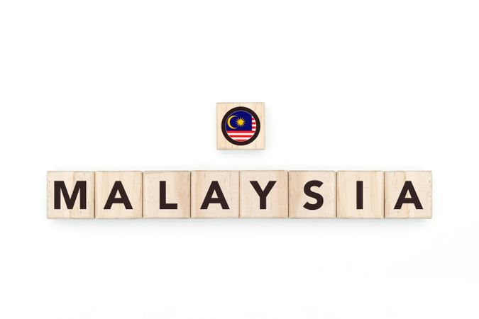 Wooden blocks bearing the name and flag of Malaysia. Malaysian and Southeast Asian Culture, national identity, travel, and geography in a copy space design.