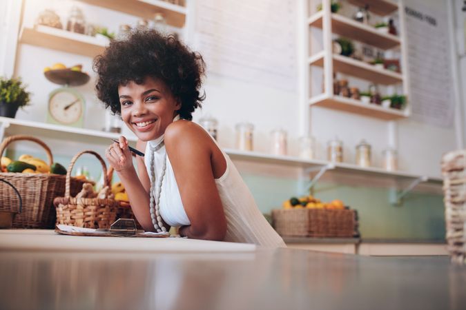 Portrait of smiling young woman working in a juice bar