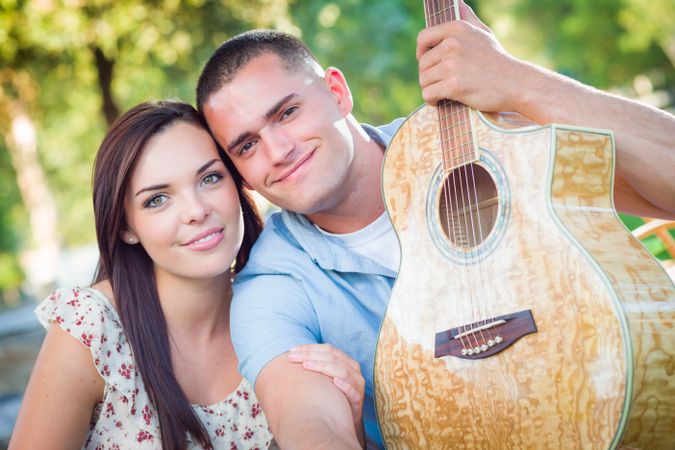 Young Adult Couple Portrait with Guitar in the Park.