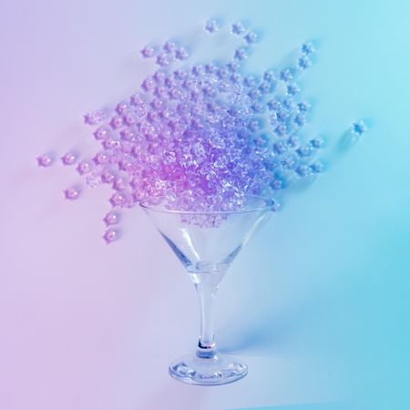 Martini glass with spilled pink glitter in vibrant bold gradient holographic colors