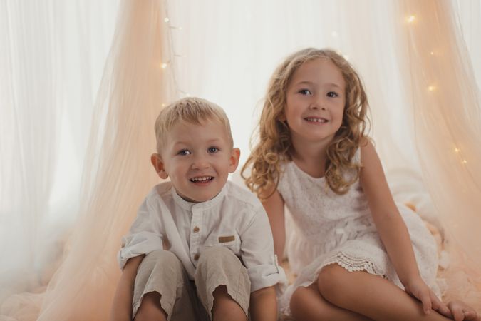 Sister embracing little brother at home
