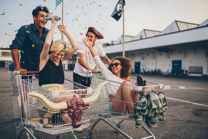 Friends throwing confetti while racing in shopping carts