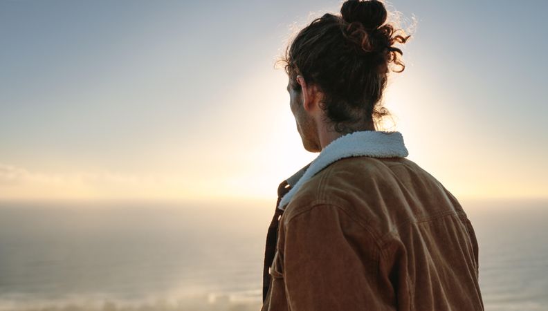 Rear view of young man overlooking sea