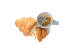 Looking down at grey cup of coffee and croissant isolated on plain background