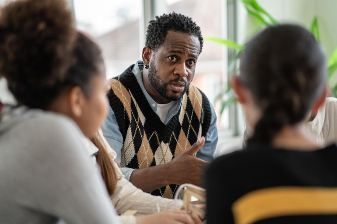 Male teacher leading science lessons around a table of students