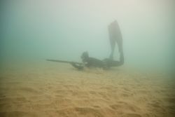 Anonymous man spearfishing in sea water