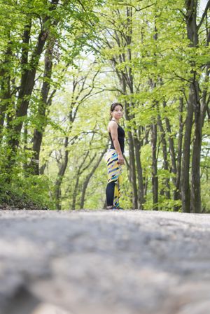 Athletic woman standing looking to her side in the forest