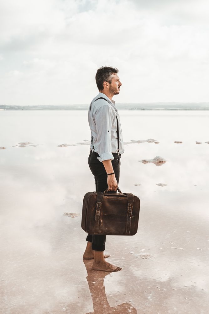 Fancy man with suitcase gazing at seaside