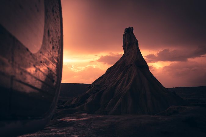 Stone peak in desert against evening sky