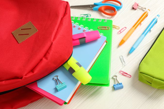 Flat lay composition with backpack and school supplies on wooden background