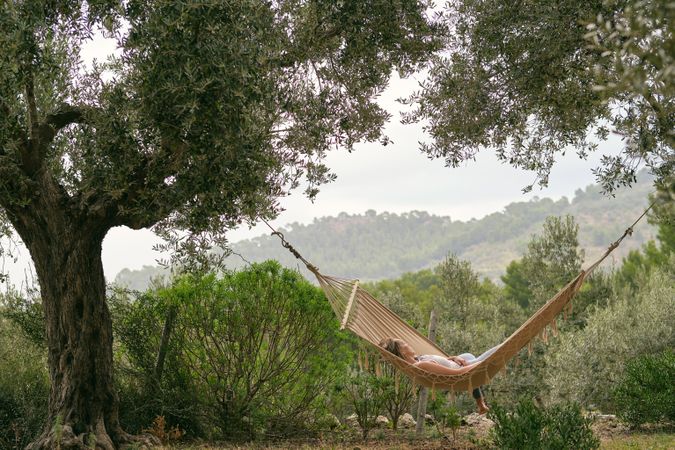 Relaxed anonymous woman resting on hammock