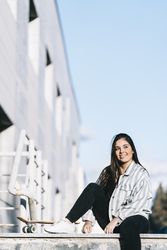Young woman posing with skateboard