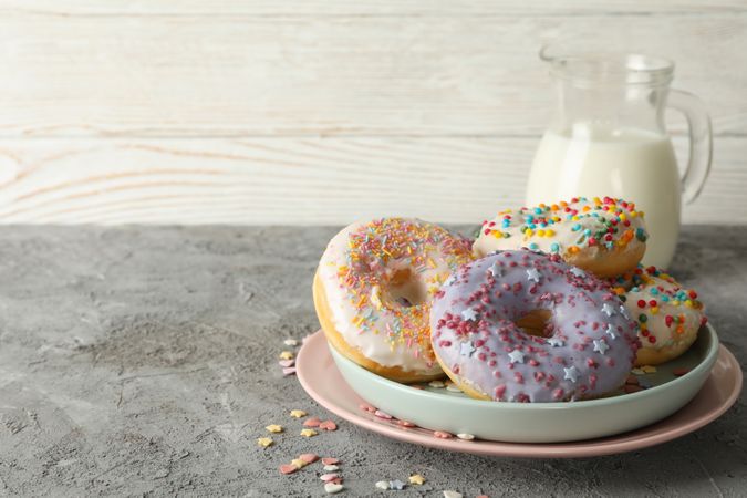 Concept of tasty food with donuts and milk on gray background