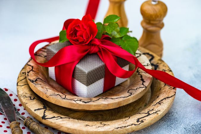 Table setting with red rose stop giftbox