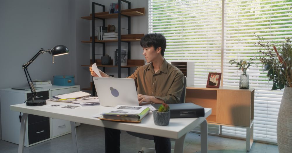 Efficient Asian Project Manager Working Diligently on a Laptop Computer in a Creative Agency Office