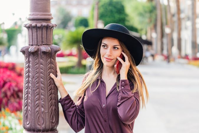 Woman in trendy outfit talking on smartphone