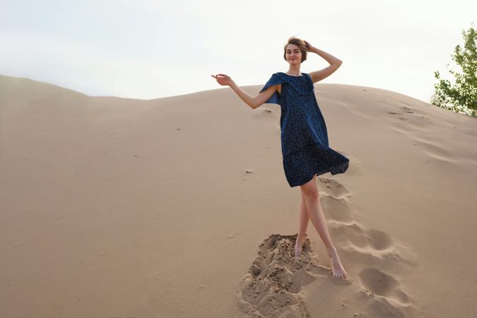 Woman in dress walking  on sandy dunes