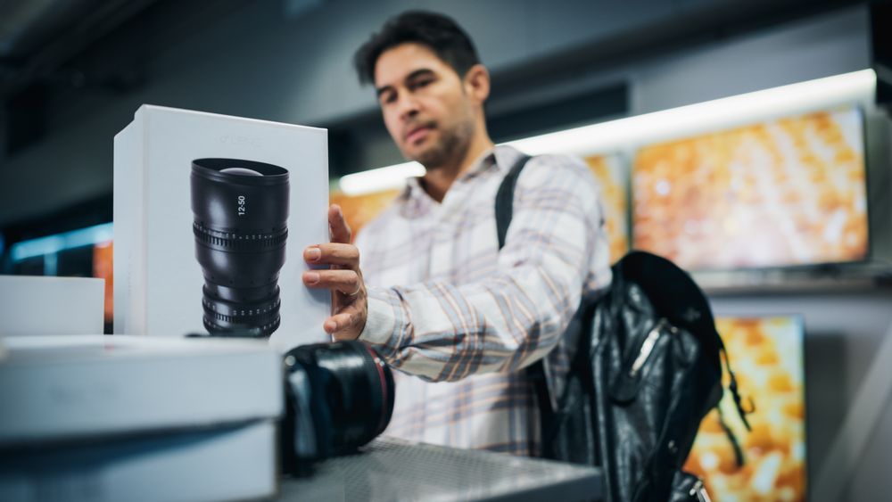 Customer Comparing Different Photo Lens Features, Sale Prices and Image Quality in a Photography Shop