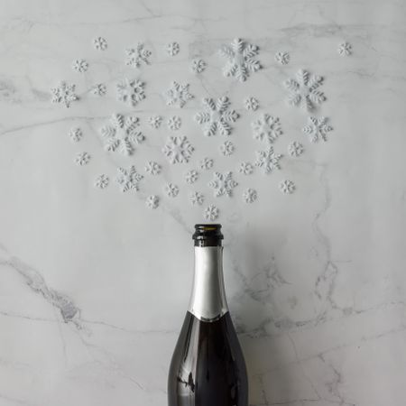 Champagne bottle with snow flakes on marble background
