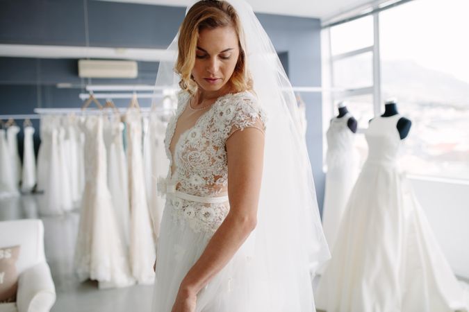 Female trying her wedding dress at bridal boutique