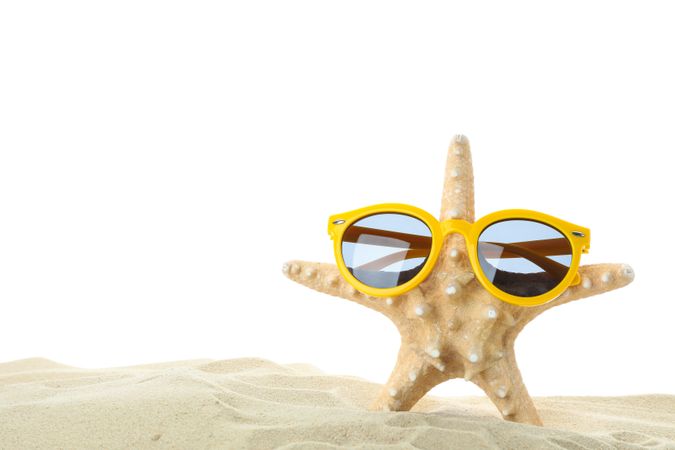 Starfish with sunglasses on clear sea sand isolated on blank background. Summer vacation