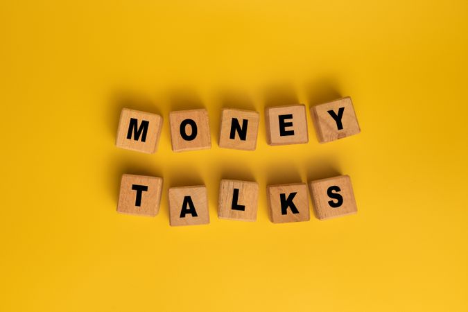 money talks words on wooden blocks isolated on orange background