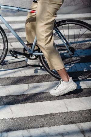 Cropped image of a person riding a blue bicycle