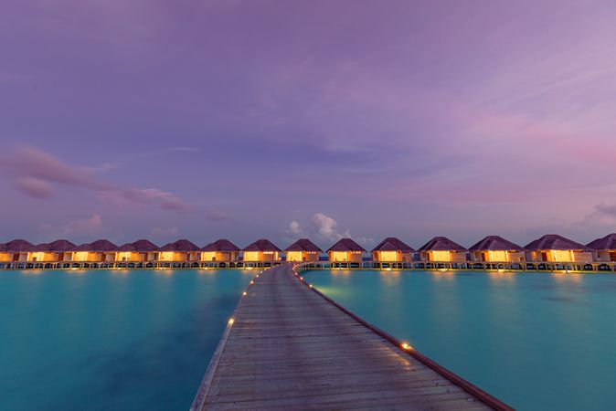 Overwater bungalows lit up at night