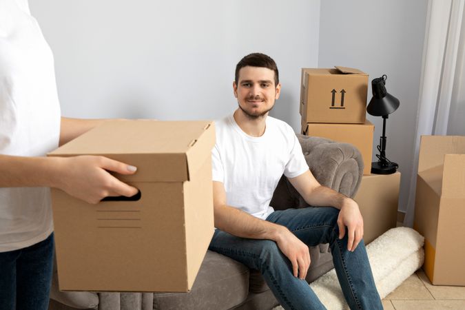 Moving concept, man with boxes in apartment.