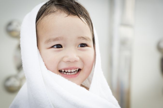 Smiling Boy Having Fun and Wrapped in Towel at the Water Park