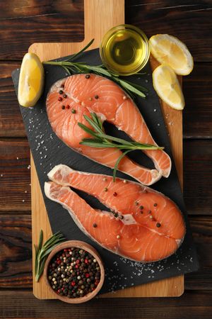 Composition with salmon meat and spices on wooden background, top view