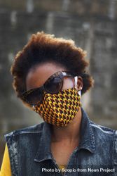Portrait of a woman in a dark and yellow face mask outdoors 0gQAj4
