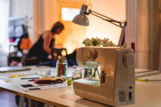 Modern sewing machine on table at fashion studio and showroom