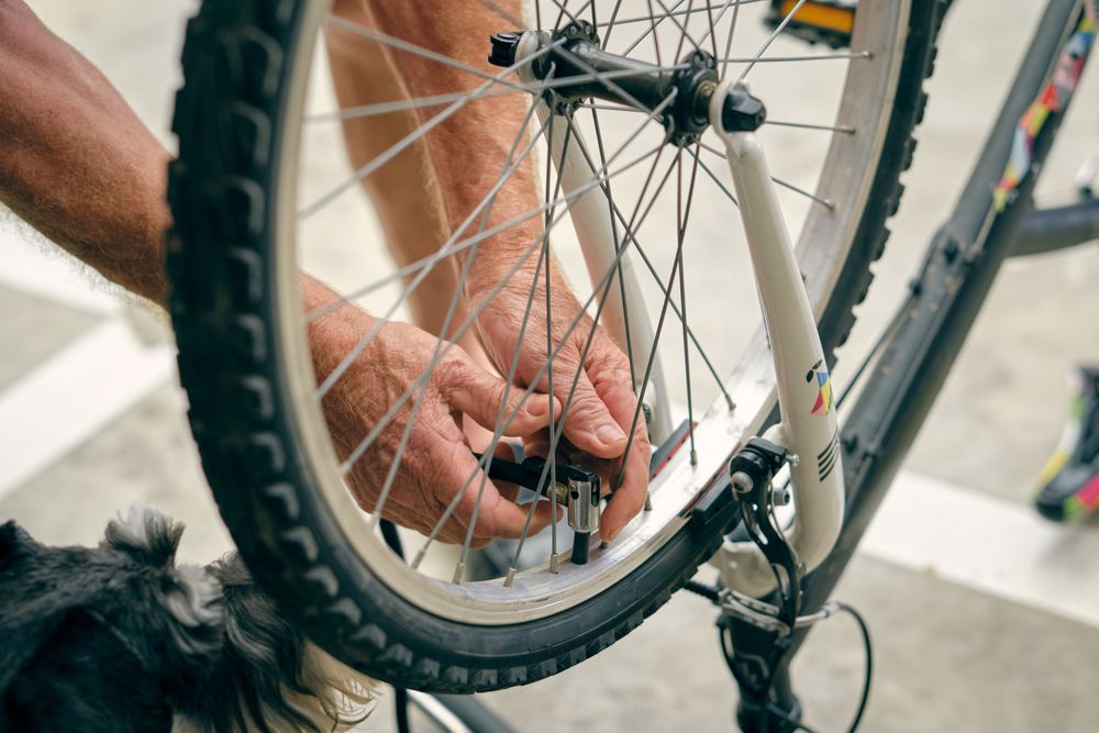 Unrecognizable man pumping up bicycle wheel