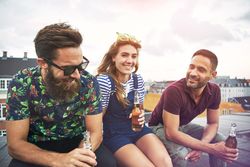 Group of happy people with beer on a roof