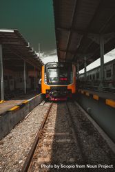 Orange train on rail 0KLQZ5