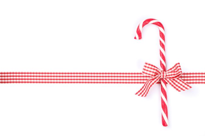 Sweet candy cane with bow isolated on plain background