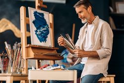 Male artist reviewing his paint brushes