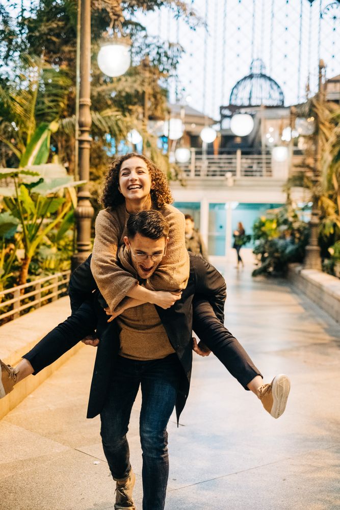 Man carrying happy girlfriend on back